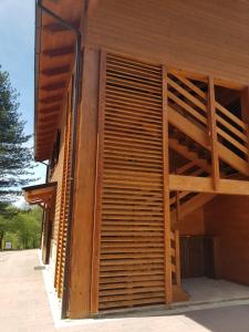 een houten gebouw met een groot raam aan de zijkant bij Lorica Suite Lago in Lorica