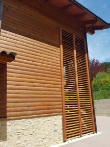 a building with a wooden wall with a shutter at Lorica Suite Lago in Lorica