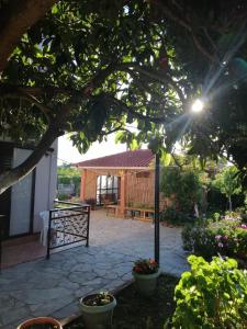 a garden with a gate and a house with a patio at Armonia Studios in Agios Georgios