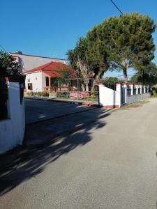 a street with a white fence and a house at Armonia Studios in Agios Georgios