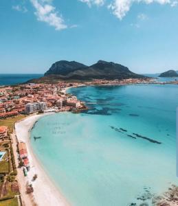 z powietrza widok na plażę z łodziami w wodzie w obiekcie Appartamenti delfini terza spiaggia w mieście Golfo Aranci
