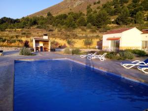 a large swimming pool with chairs and a house at Casa Pasamee in La Romana