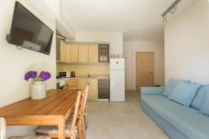 a living room with a table and a blue couch at Siviri Forest View Apartment in Siviri