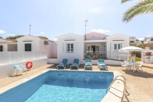 a villa with a swimming pool in front of a house at Villa Lali in Punta Grossa