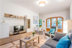 sala de estar con sofá y TV en Villa Lali en Arenal d'en Castell