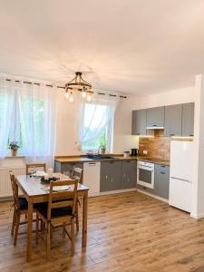 a kitchen with a wooden table and a dining room at Apartamenty Oleńka II - Szczytno Mazury in Szczytno