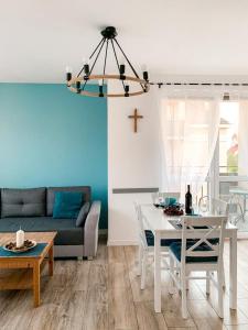 a living room with a table and a cross on the wall at Apartamenty Oleńka I - Szczytno Mazury in Szczytno