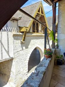 a house with a bridge on the side of it at L'Entrée Chambres d'Hôtes Bar & Restaurant in Castillonnès