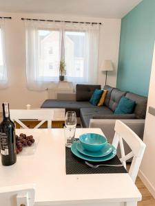 a living room with a table with a bottle of wine at Apartamenty Oleńka I - Szczytno Mazury in Szczytno