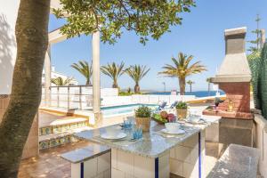 a table on a balcony with a view of the ocean at Villa Mar Azul in Arenal d'en Castell