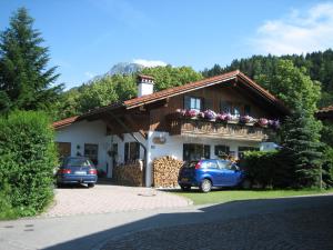 a house with two cars parked in front of it at Haus Osterried in Schwangau