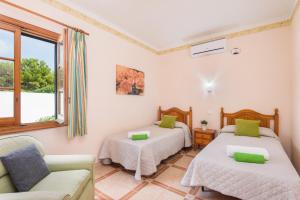 a room with two beds and a couch at Villa Mar Azul in Arenal d'en Castell