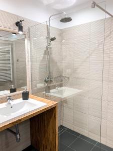 a bathroom with a sink and a shower at Apartamenty Oleńka I - Szczytno Mazury in Szczytno