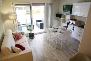 ein Wohnzimmer mit einem Sofa und einem Tisch mit Stühlen in der Unterkunft Magnifique 3P - French riviera - 3mn beach - Air Conditioning - Balcony in Juan-les-Pins