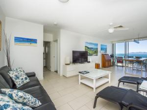 a living room with a couch and a table at 1 Bright Point Apartment 5102 in Nelly Bay