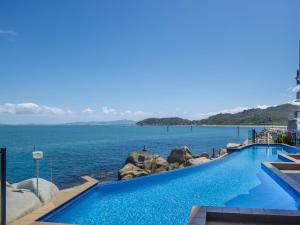 a swimming pool with a view of the ocean at 1 Bright Point Apartment 4502 in Nelly Bay