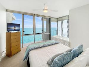a bedroom with a bed and a large window at 1 Bright Point Apartment 4502 in Nelly Bay