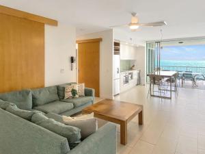 a living room with a couch and a table at 1 Bright Point Apartment 4502 in Nelly Bay