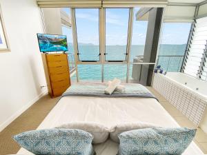 a bedroom with a tub and a large window at 1 Bright Point Apartment 4502 in Nelly Bay