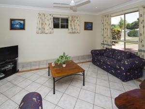 a living room with a couch and a table at Island Dreams in Nelly Bay