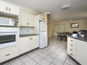 a kitchen with white appliances and a dining room at Island Dreams in Nelly Bay