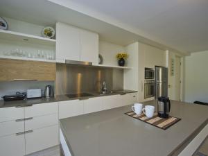 een keuken met witte kasten en een aanrecht bij Blue on Blue Apartment 921 in Nelly Bay