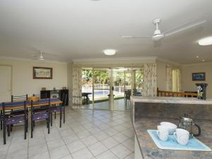 cocina y sala de estar con mesa y sillas en Island Dreams, en Nelly Bay