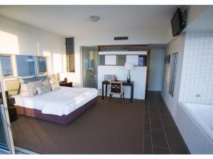 - une chambre avec un lit, un bureau et une baignoire dans l'établissement 1 Bright Point Apartment 5201, à Nelly Bay
