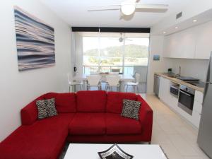 un soggiorno con divano rosso e una cucina di 1 Bright Point Apartment 1402 a Nelly Bay