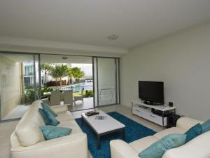 sala de estar con sofá y TV en Blue on Blue Apartment 812, en Nelly Bay