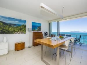 a kitchen with a dining table and a view of the ocean at 1 Bright Point Apartment 5102 in Nelly Bay