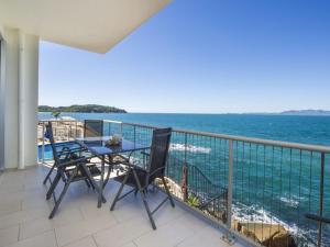 a balcony with a table and chairs and the ocean at 1 Bright Point Apartment 5102 in Nelly Bay