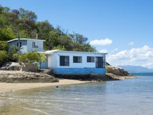 a blue and white house on the shore of the water at Blue on Cockle in Picnic Bay