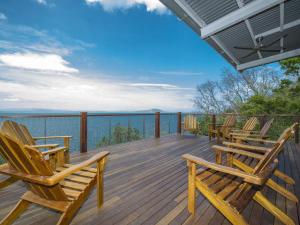 a deck with chairs and a view of the water at Driftwood in Picnic Bay