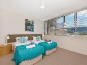 a bedroom with two beds and a large window at 1 Bright Point Apartment 4501 in Nelly Bay