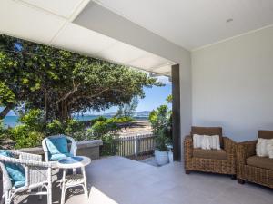 Picnic Bay的住宿－Reflections Turquoise Villa 4，一个带椅子和桌子的海景庭院