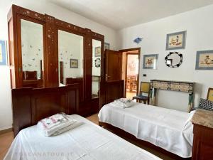 una camera da letto con due letti e uno specchio di Casa Bianca Villa pool with sea view, fenced garden, barbecue by ToscanaTour a Castellina Marittima Altre 43 foto