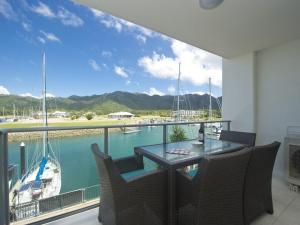 a balcony with a table and chairs and a view of a marina at Blue on Blue Superior Studio Room 1241 in Nelly Bay