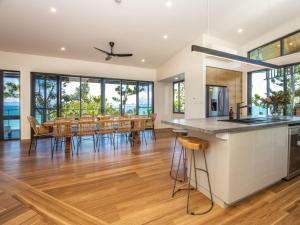 a kitchen and dining room with a table and chairs at Headland House in Picnic Bay