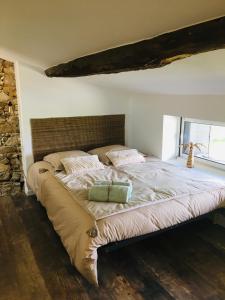 a bedroom with a large bed with a stone wall at La maison coup de cœur de Pont Caffino 9 couchages plus 2 sur demande in Maisdon-sur-Sèvre
