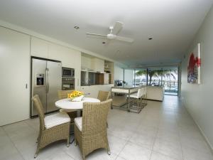 a kitchen and dining room with a table and chairs at Blue on Blue Apartment 912 in Nelly Bay