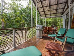 a porch with chairs and a trash can and a grill at Sunbird Retreat in Horseshoe Bay