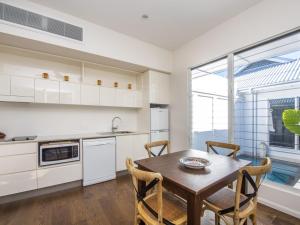eine Küche mit einem Holztisch und Stühlen im Zimmer in der Unterkunft Reflections Topaz Villa 2 in Picnic Bay