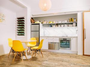 a kitchen with yellow chairs and a table at The Little Bush Hut in Nelly Bay