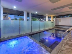 a swimming pool with blue lights in a building at Maggies Beachfront Apartment 8 in Horseshoe Bay