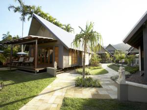 una casa con una palmera delante en Pure Magnetic Villa 1, en Nelly Bay