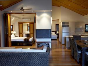 a living room with a television and a bedroom at Pure Magnetic Villa 1 in Nelly Bay