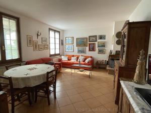 un soggiorno con un divano e un tavolo di Casa Bianca Villa pool with sea view, fenced garden, barbecue by ToscanaTour a Castellina Marittima