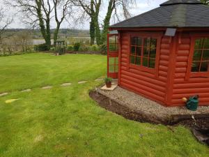 uma pequena casa de brincar vermelha num quintal em Willowbank House em Enniskillen