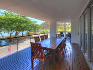 ein Esszimmer mit einem Tisch und Stühlen auf einer Terrasse in der Unterkunft Maggies Beachfront Apartment 10 in Horseshoe Bay